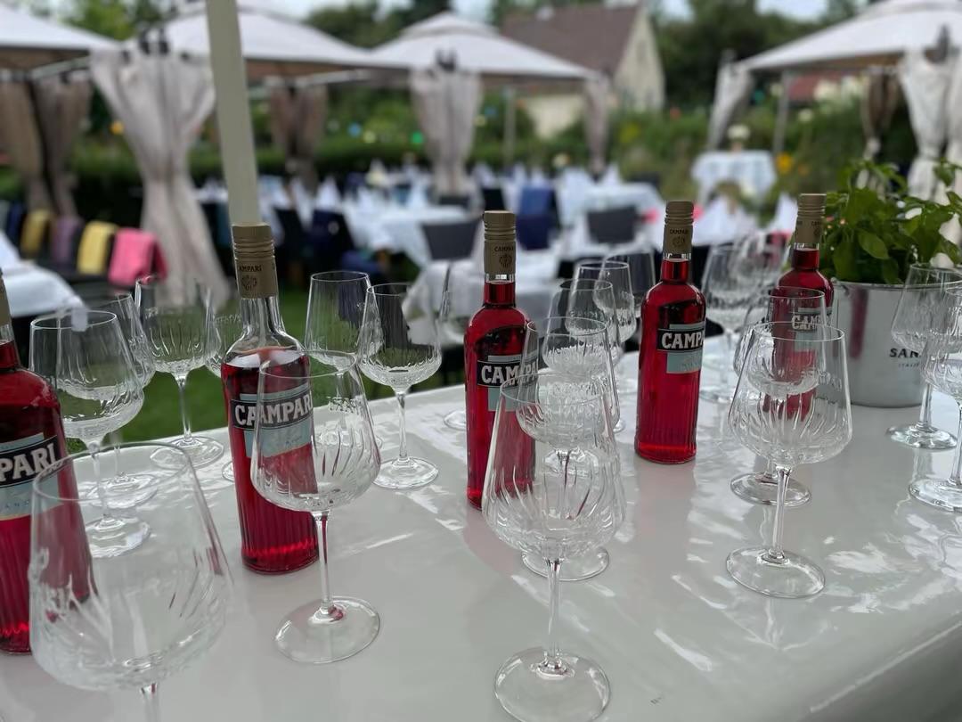 Aperitivo im Garten: Campari-Flaschen und Gläser auf festlich gedeckter Tafel